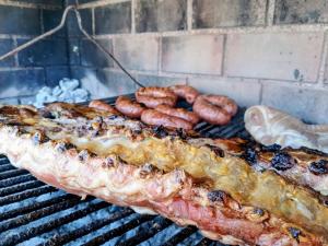a rack of meat and sausages on a grill at El Descanso in Camet Norte