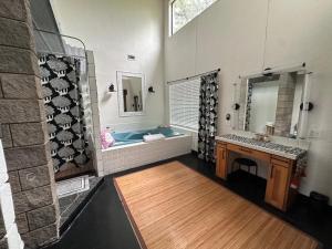 a bathroom with a tub and a sink and a mirror at Sunset Oaks Retreat Events, Farm Animals & Views in Saint Jo +117 photos