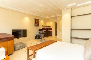 een woonkamer met een bed en een televisie bij Excellent apartment plus hot tub in Marrakesh