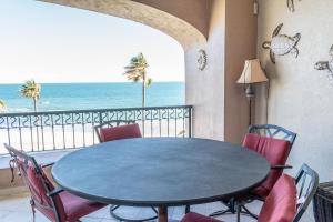 a dining room with a table and chairs and the ocean at Sonoran Spa W404 in Campo del Medio