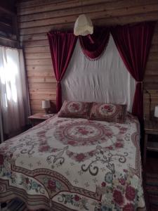 a bedroom with a large bed with red curtains at Runaway Pineapple Lodge in Mangrove Bight