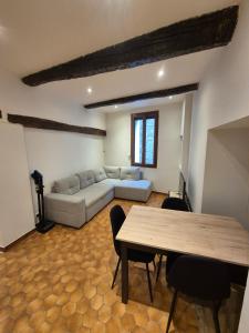 a living room with a couch and a table at Appartement chaleureux au charme ancien au calme in Draguignan