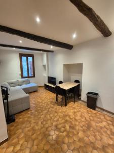 a living room with a couch and a table at Appartement chaleureux au charme ancien au calme in Draguignan