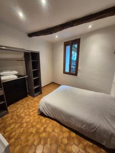 a bedroom with a large white bed and a window at Appartement chaleureux au charme ancien au calme in Draguignan