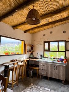 a kitchen with a sink and a table with chairs at Cabaña Paraíso Cachi in Cachí