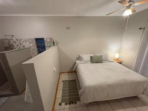 a small room with a bed and a staircase at Lily Palms Rest in Tzaneen