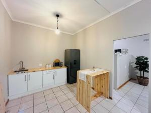 a kitchen with a wooden table and a refrigerator at Lily Palms Rest in Tzaneen