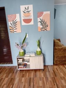 Una mesa de café con plantas en una pared azul. en Cantinho da Ane, en Morro Reuter 1 foto más