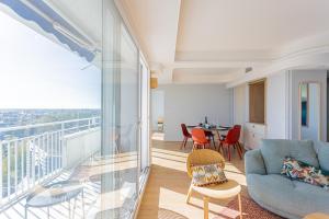 un salon avec un canapé et un balcon dans l'établissement Appartement Design contemporain vue sur Orléans, à Orléans