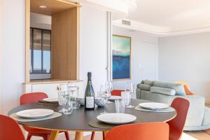 - une table à manger avec des chaises rouges et une bouteille de vin dans l'établissement Appartement Design contemporain vue sur Orléans, à Orléans