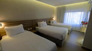 a hotel room with two beds and a window at Harmony City Hotel - Jerusalem in Jerusalem