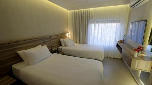 a hotel room with two beds and a window at Harmony City Hotel - Jerusalem in Jerusalem