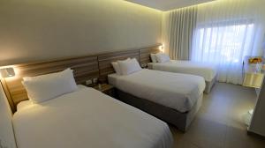 a hotel room with two beds and a window at Harmony City Hotel - Jerusalem in Jerusalem