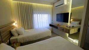 a hotel room with two beds and a flat screen tv at Harmony City Hotel - Jerusalem in Jerusalem +7 photos