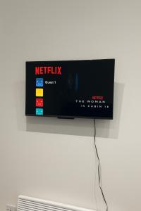 a tv on a wall with a netflix sign on it at 77 Lovely Self-Contained Studio Easy Access to Central London in Northolt