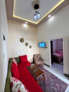 Una sala de estar con un sofá rojo y una mesa. en Cozy airconditioned two bedroom apartments شقق فندقية مكيفة للإيجار, en Ras El Bar