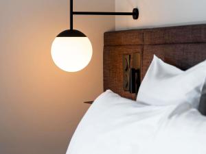 a bedroom with a white bed and a lamp at Novotel Belfort Centre Atria in Belfort +217 photos