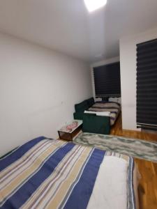 a room with two beds and a couch in it at Stan u centru grada Rozaje in Rožaje