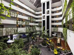 arium of an apartment building with plants and trees at Novotel Darwin CBD in Darwin