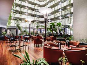 a restaurant with chairs and tables and a building at Novotel Darwin CBD in Darwin