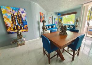 a dining room with a wooden table and blue chairs at Espectacular Apto remodelado, de lujo y a pie de Playa con vista al mar in Manzanillo +51 photos