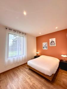 Un dormitorio con una cama grande y una ventana. en Prestige House & Spa, en Auvilliers