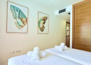 deux lits dans une chambre avec deux tableaux au mur dans l'établissement Casa Calma - Mar Menor Golf Resort, à Torre-Pacheco 19 autres photos