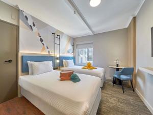 ein Hotelzimmer mit zwei Betten und einem Stuhl in der Unterkunft ibis Perth in Perth + 153 Fotos