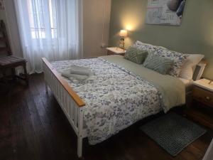 a bedroom with a large bed with a blanket and a window at Number 22 - Le Dorat - Apartment 3 with garden & free parking in Le Dorat