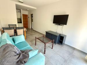 a living room with a blue couch and a tv at Departamento un dormitorio 38 in La Plata