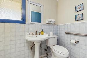 a white bathroom with a toilet and a sink at Hamakua Hale Ohana Country Retreat in Papaikou +10 photos