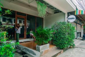 通萨拉Kiko's Hostel的女人站在商店外面