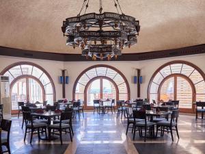 a dining room with tables and chairs and a chandelier at Mercure Hurghada Hotel in Hurghada