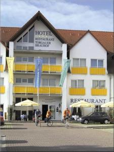 um grupo de pessoas a andar de bicicleta em frente a um hotel em Hotel Torgauer Brauhof em Torgau