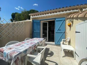 a table and chairs on a patio with a house at Maison la pinède in Oignies