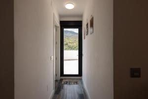 un couloir avec une porte donnant sur une fenêtre dans l'établissement Comeback el Rinconcito de Guajar, à Guájar-Faragüit