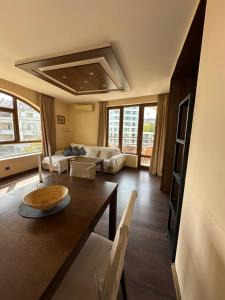 ein Wohnzimmer mit Tisch und Couch in der Unterkunft Sea view apartment next to Sea garden and beach in Warna