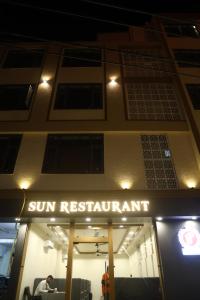 Un letrero de restaurante con sol en el lateral de un edificio en Hotel Sun Palace, en Somnath