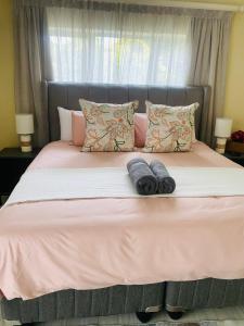 a bed with two towels on top of it at PJ Guest House in Gqeberha