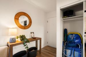 a living room with a table and a mirror at Modern studio, AC, king bed, private lanai in Princeville