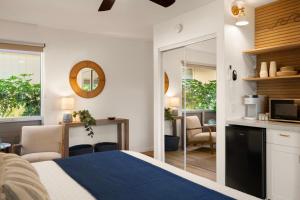 a bedroom with a bed and a kitchen with a counter at Modern studio, AC, king bed, private lanai in Princeville