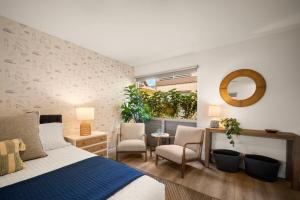 a bedroom with a bed and chairs and a mirror at Modern studio, AC, king bed, private lanai in Princeville +25 photos