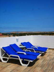 een groep blauwe stoelen op een dak bij Dar Iziki Separate Apartments in Sidi Kaouki