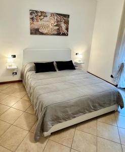 a large bed in a room with two lamps at Top Apartment 2 in Castel d'Azzano