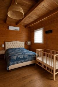 a bedroom with a crib in a wooden room at חוות אדמה ושמיים יבנאל in Yavneʼel