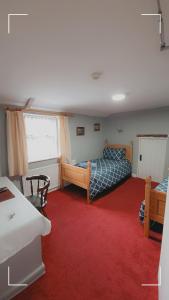 a bedroom with two beds and a red carpet at The Horse and Groom Guest House in Swaffham