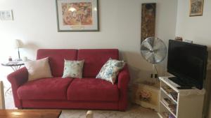 a red couch with pillows in a living room at La Libellula in Capannoli