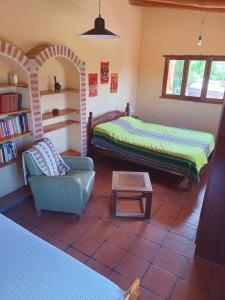 ein Schlafzimmer mit einem Bett, einer Couch und einem Tisch in der Unterkunft Mirá el Cardón in Tilcara