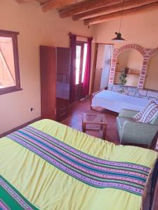 ein Schlafzimmer mit Bett und ein Wohnzimmer in der Unterkunft Mirá el Cardón in Tilcara