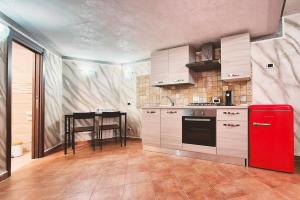 a kitchen with a red refrigerator and a table at Studio apartment in Rome with a pool in Colonna